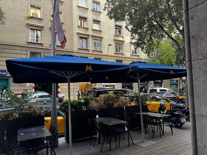 Terraza con 6 mesas, 20 sillas, 4 parasoles.